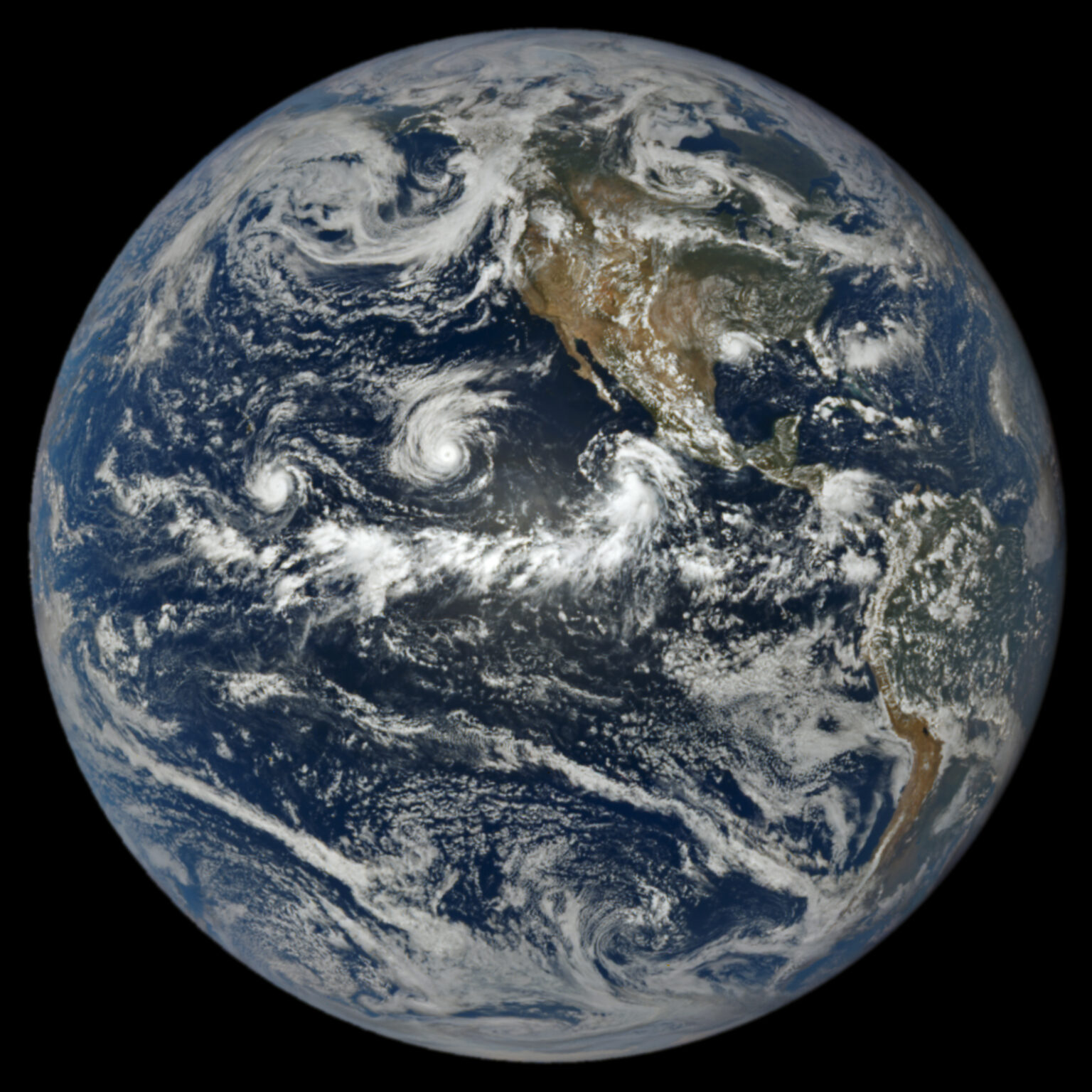 Satellite imagery of the Earth showing three tropical storms in the Pacific west of the United States and Mexico.